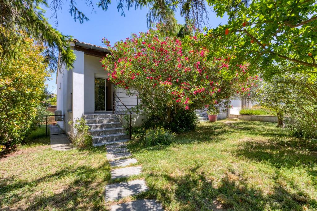 a house with a tree with pink flowers at Gîte Gignac Vallée De L'hérault in Gignac