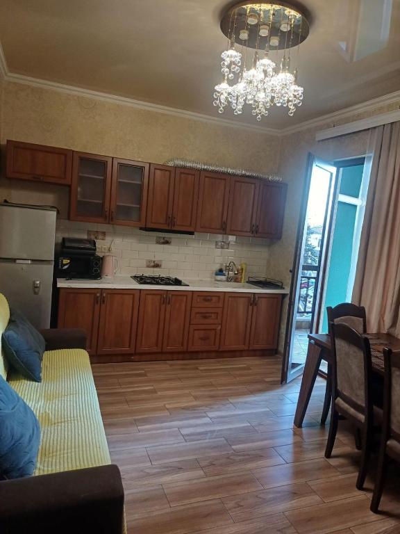 a kitchen with wooden cabinets and a chandelier at Your warm host in Kutaisi