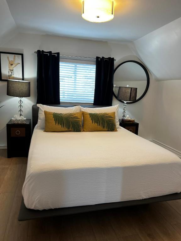 a bedroom with a bed with two lamps and a mirror at Niagara Escape Loft in St. Catharines