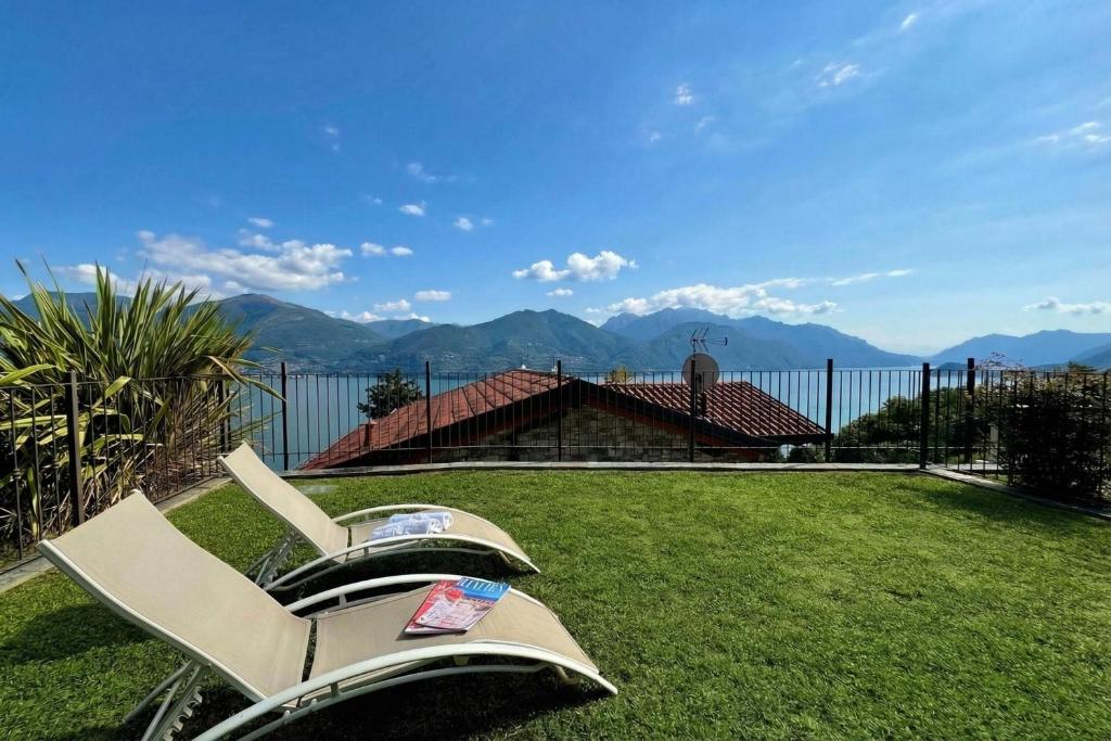 a chair on a lawn with mountains in the background at Villa Aurelia in Plesio