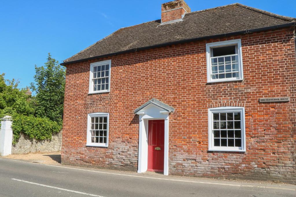 a red brick building with a red door at The Old School House in Chichester
