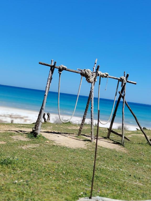 a wooden structure on the beach near the ocean at Kelibia ezzahra 2min a pied du plage in Ḩammām al Ghazzāz