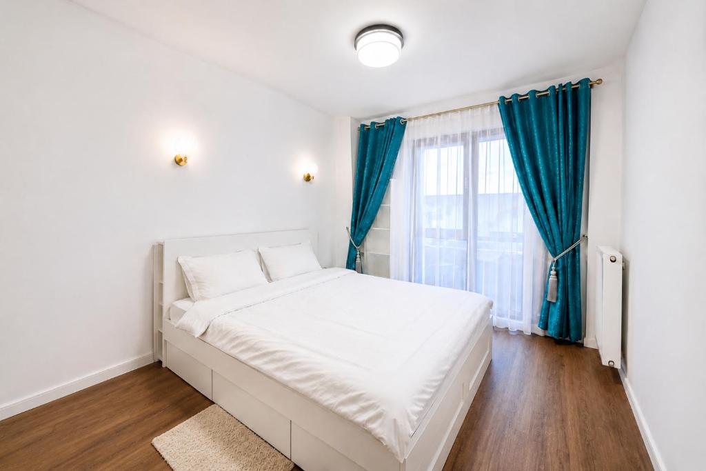 a white bed in a room with a window at Spacious 3-Room Apartment - NEW Building in Bucharest