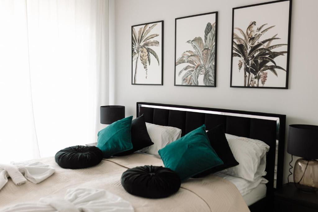 a bedroom with a bed with green pillows on it at GOLDEN HAUS Opole - Black Velvet & Dark Elegance in Opole