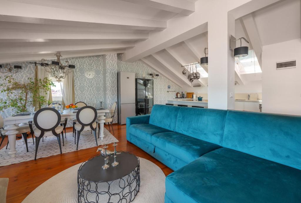 a living room with a blue couch and a table at Villa San Martein in Rovinj