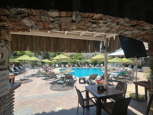 a pool with chairs and tables and umbrellas at Sun Blue Apart Hotel in Marmaris