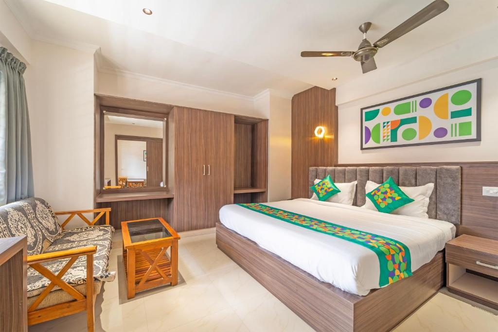 a bedroom with a bed and a chair at Treebo Regalia, Near Medical College & Pattom in Trivandrum
