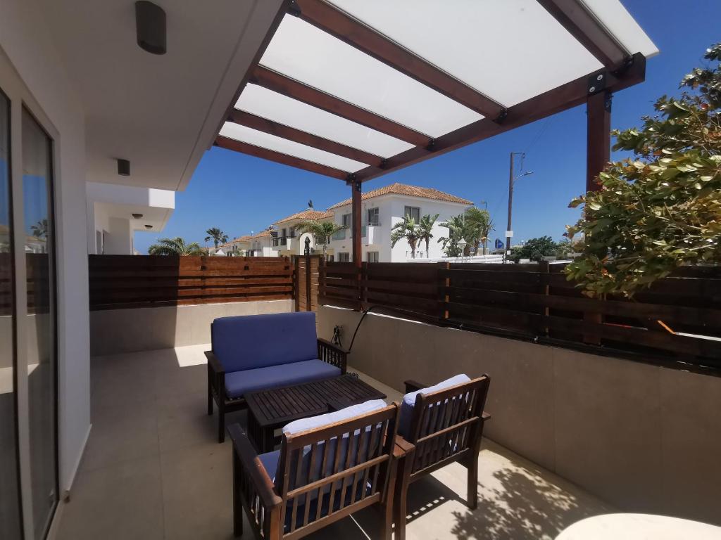 a balcony with two benches and a blue chair at Sunny coast apartment by the sea in Protaras