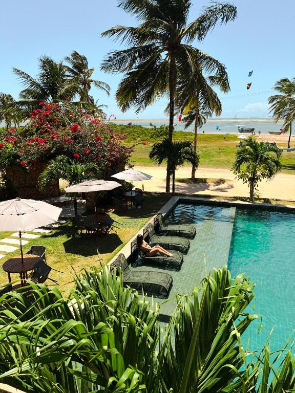 a person laying on lounge chairs next to a swimming pool at Locanda dei Venti in Itarema