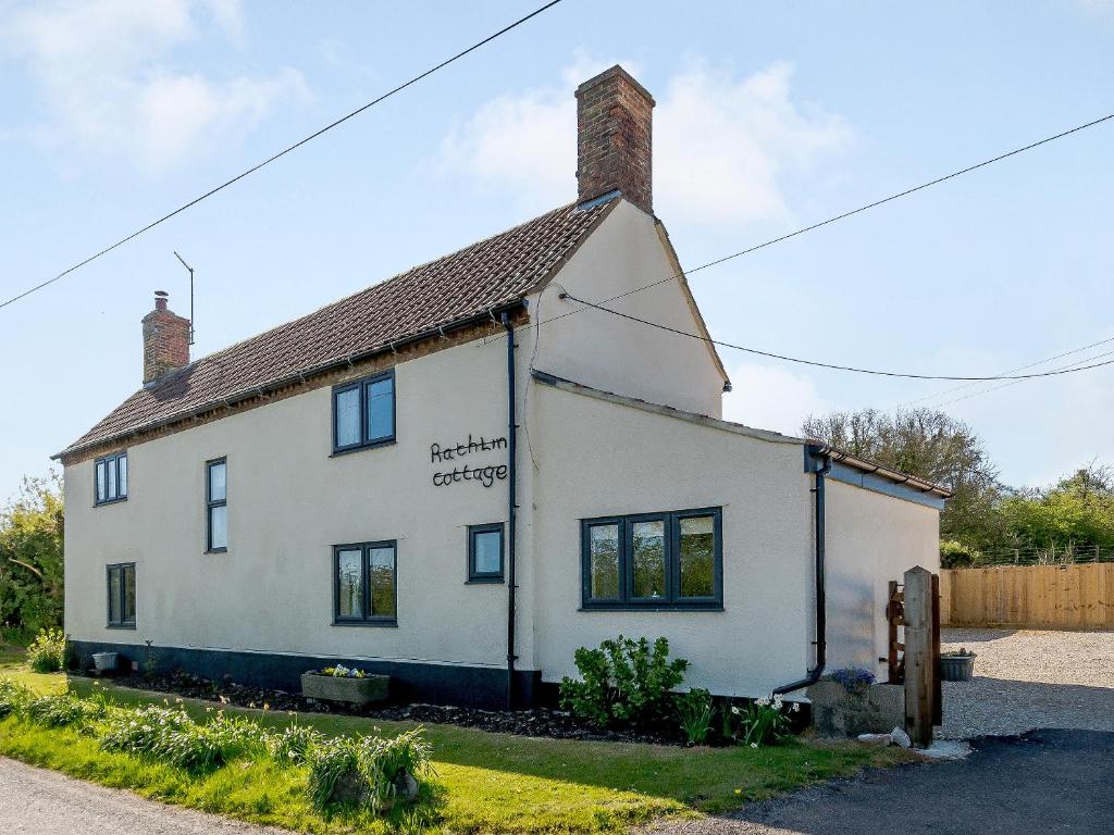 a white house with a sign on the side of it at Rathlin Cottage in Cambridge