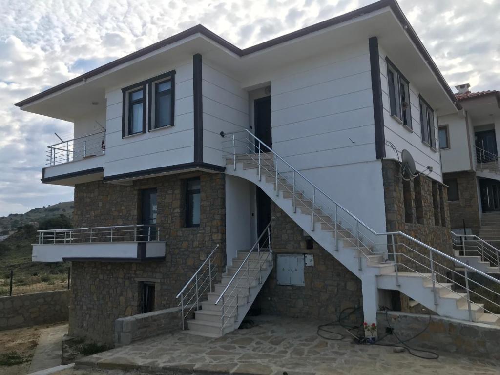 a house with stairs on the side of it at Duplex Villa with Panoramic Sea View in Gokceada Town