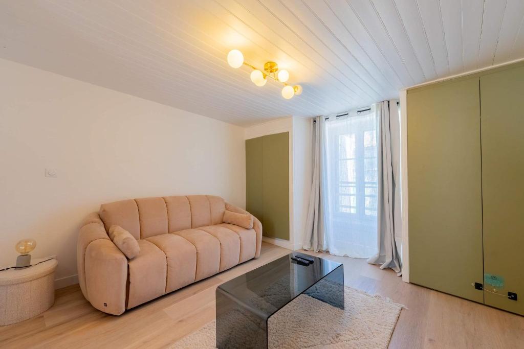 a living room with a couch and a glass table at l'Onyx in La Rochelle
