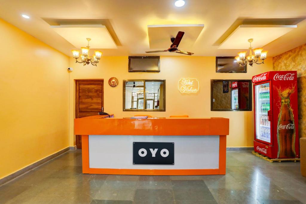 a restaurant with an orange and white counter in a room at Hotel O Value in Jabalpur
