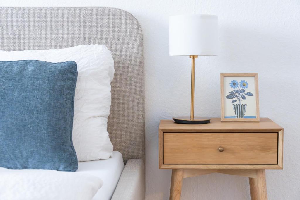 a lamp on a nightstand next to a bed at KasselRooms Design Studio in Kassel
