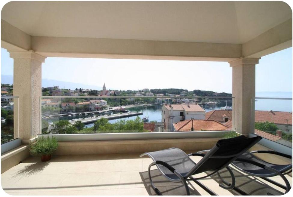 a balcony with two chairs and a view of a river at Wind Rose Apartments Sumartin in Sumartin