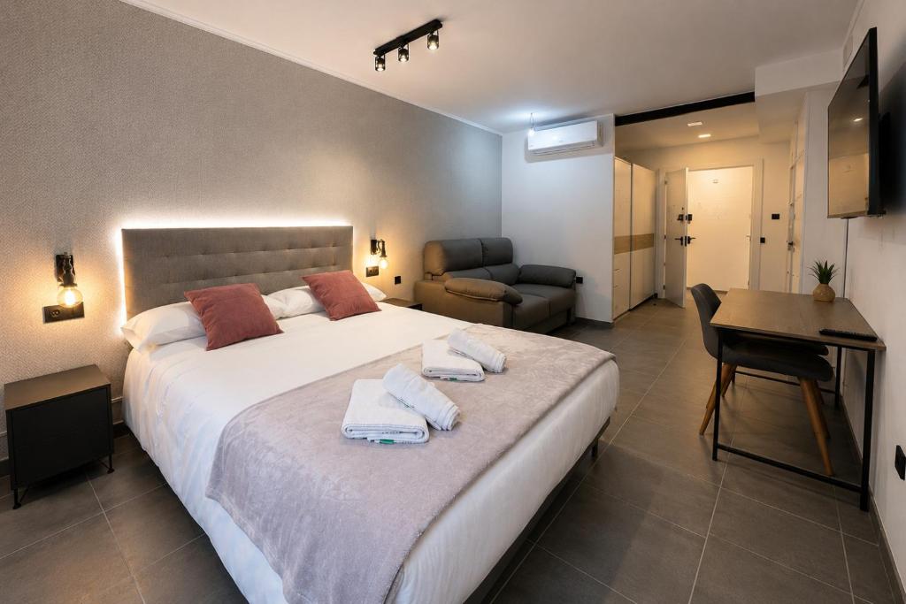 a bedroom with a large bed with towels on it at AH Rentals Suites in Vinarós