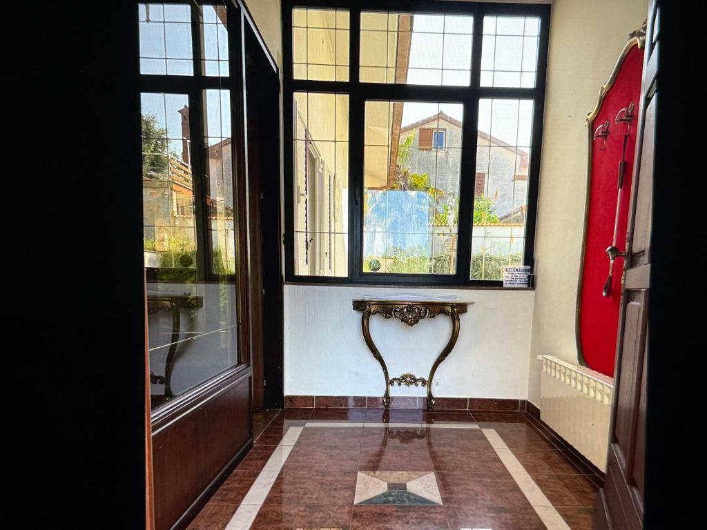 a hallway with a red door and windows at Villa Maya in Portorož