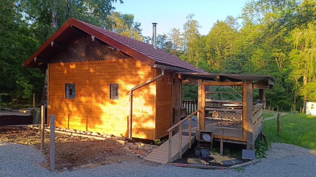 a small wooden cabin with a porch and a roof at Le chalet des paons - Le Mond'idéal in Felon