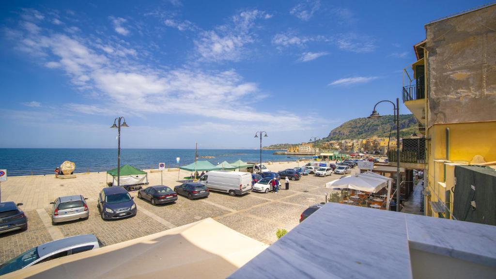 a group of cars parked in a parking lot next to the ocean at Solemar Sicilia - Casa Bella in Bagheria