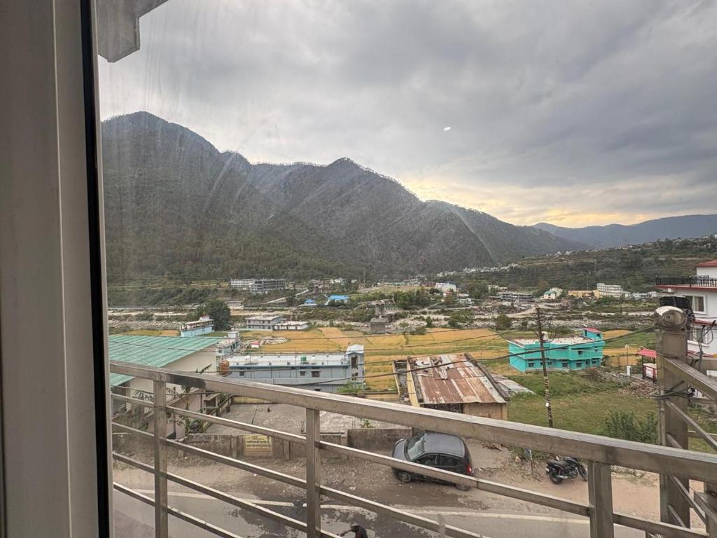 a view from a balcony of a town with mountains at Hotel Ganpati place in Uttarkāshi