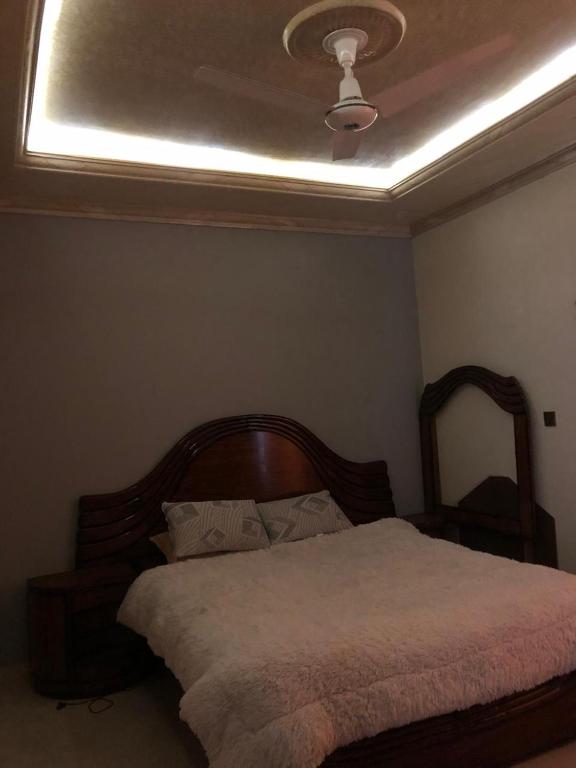 a bedroom with a large bed with a ceiling at Cozy Corner Two-Bedroom in Abbottabad