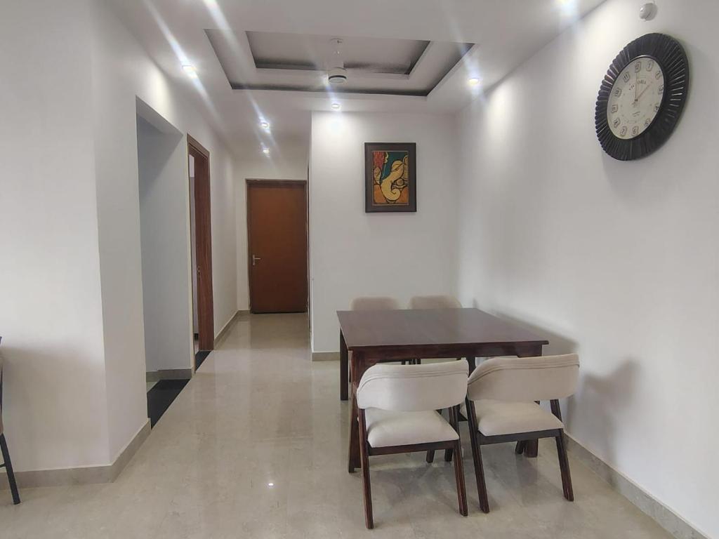 a dining room with a table and chairs and a clock at Ganga Bliss in Rishīkesh