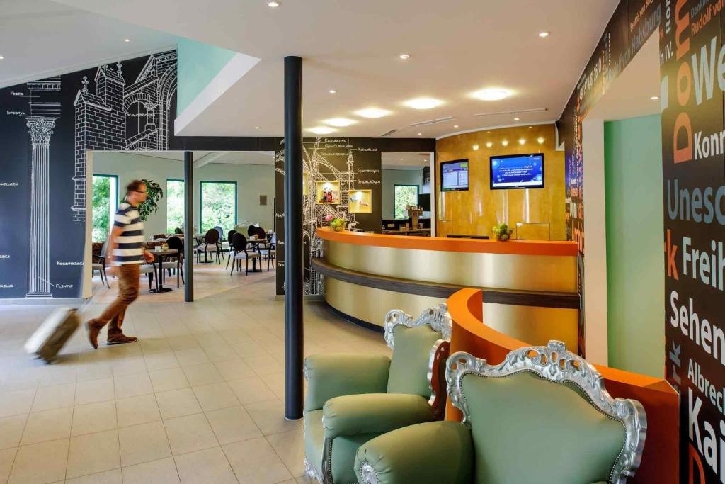 a person walking through a fast food restaurant at ibis Styles Speyer in Speyer