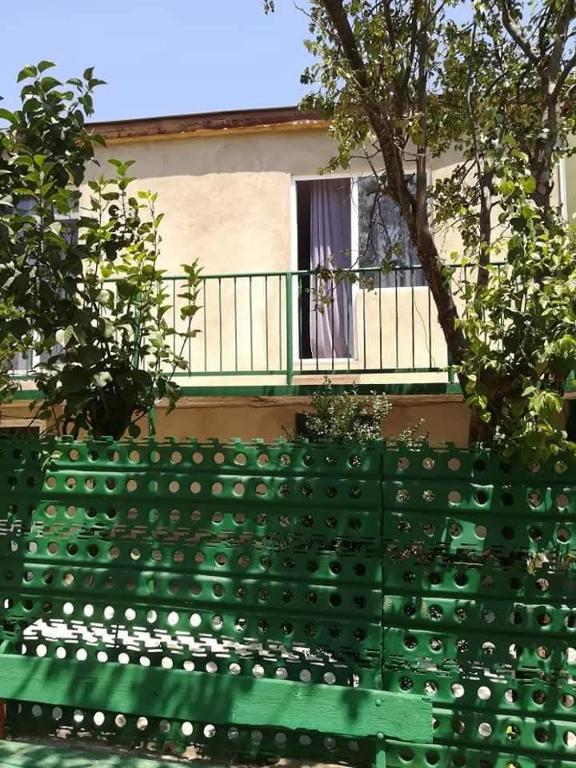 a green bench sitting in front of a building at GuestHous LUKA in Manglisi