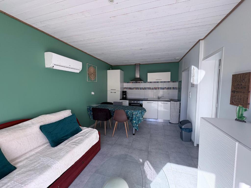 a living room with a couch and a table at Maison une chambre avec jardin in Les Sables-d'Olonne