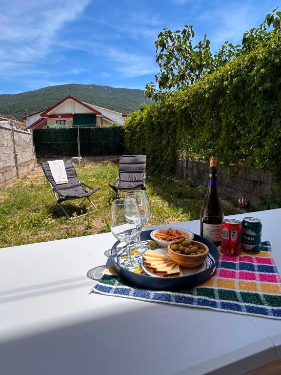 a plate of food and a bottle of wine on a table at Casa rural en La Adrada con jardín in La Adrada