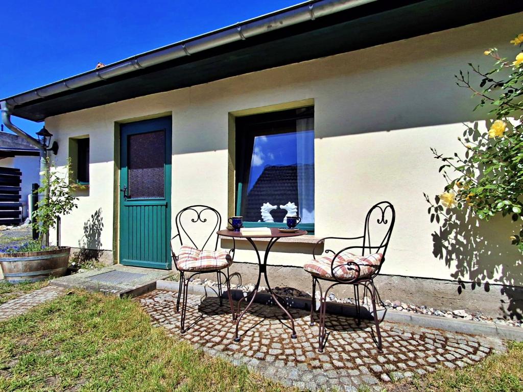 a table and two chairs in front of a house at Ferienzimmer Gleißner in Ahlbeck