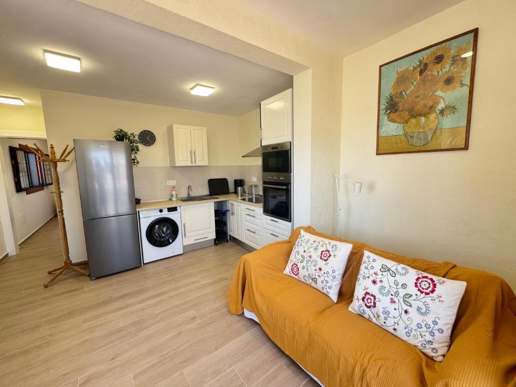 a living room with a couch and a kitchen at Casa Solano in Tías