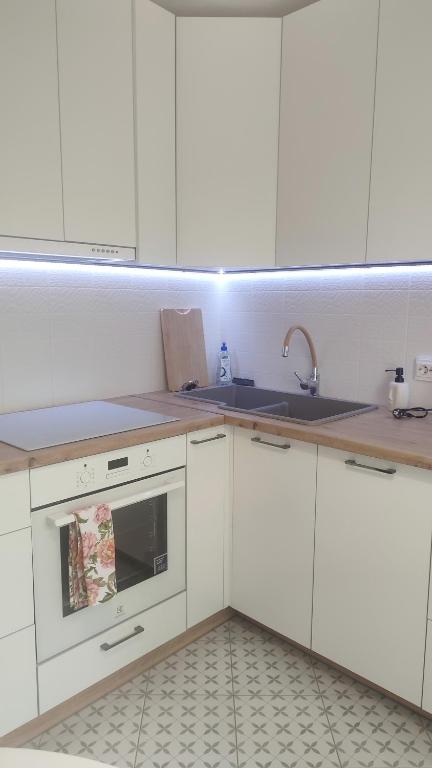 a kitchen with white cabinets and a sink at Viļāni Nākotnes in Viļāni