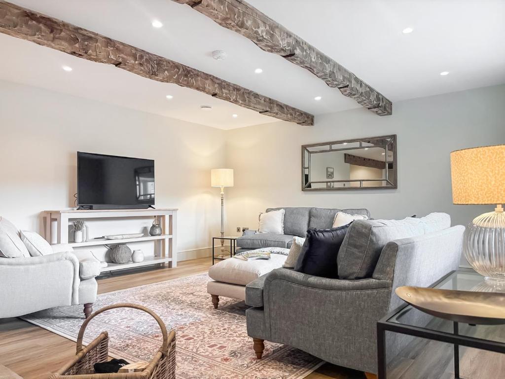 a living room with a couch and a tv at Cross Keys Cottage in Skipton