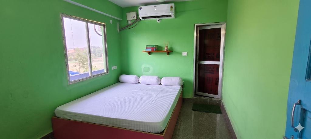 a small room with a bed in a green room at Om Siya Ram Resort in Rājgīr