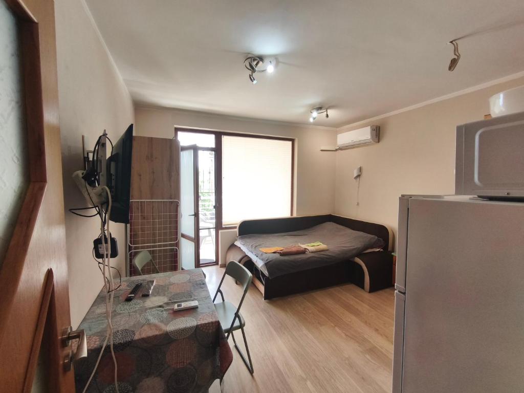 a small room with a bed and a refrigerator at Apartment in the Center 2 in Varna City