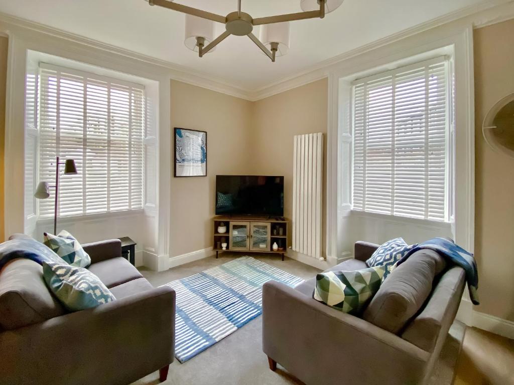 a living room with two couches and a flat screen tv at 2 Harney Peak in Portinscale