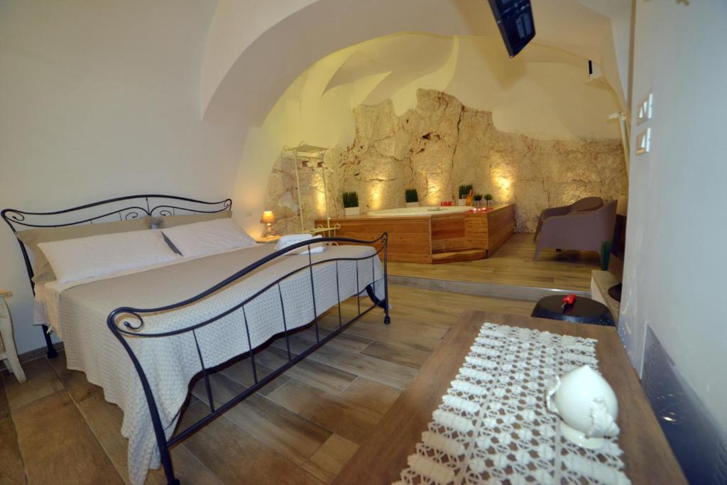 a bedroom with a bed in a room with a rock wall at Suite Grotta della luna - Romantic Luxury Jacuzzi in Ostuni