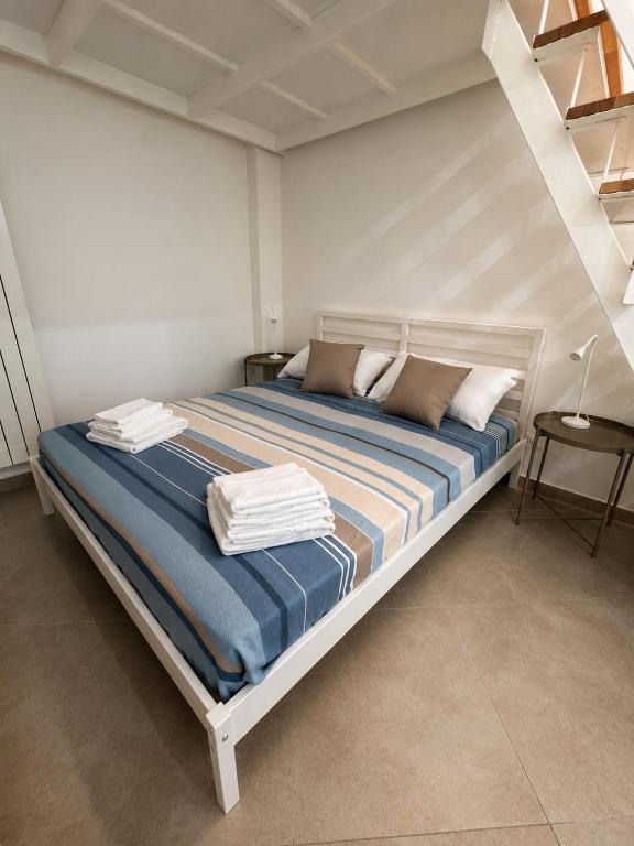 a bed in a white room with towels on it at Bukowski Loft House in Porticello