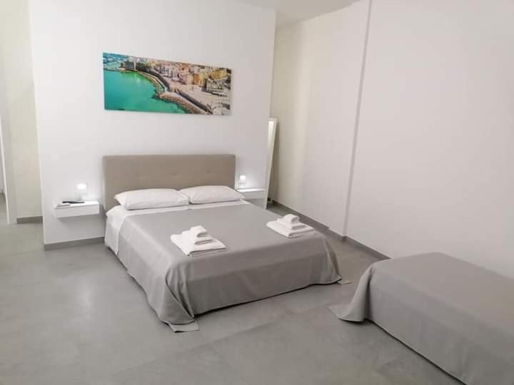 a white bedroom with a bed with two towels on it at Dimora Felline in Giurdignano