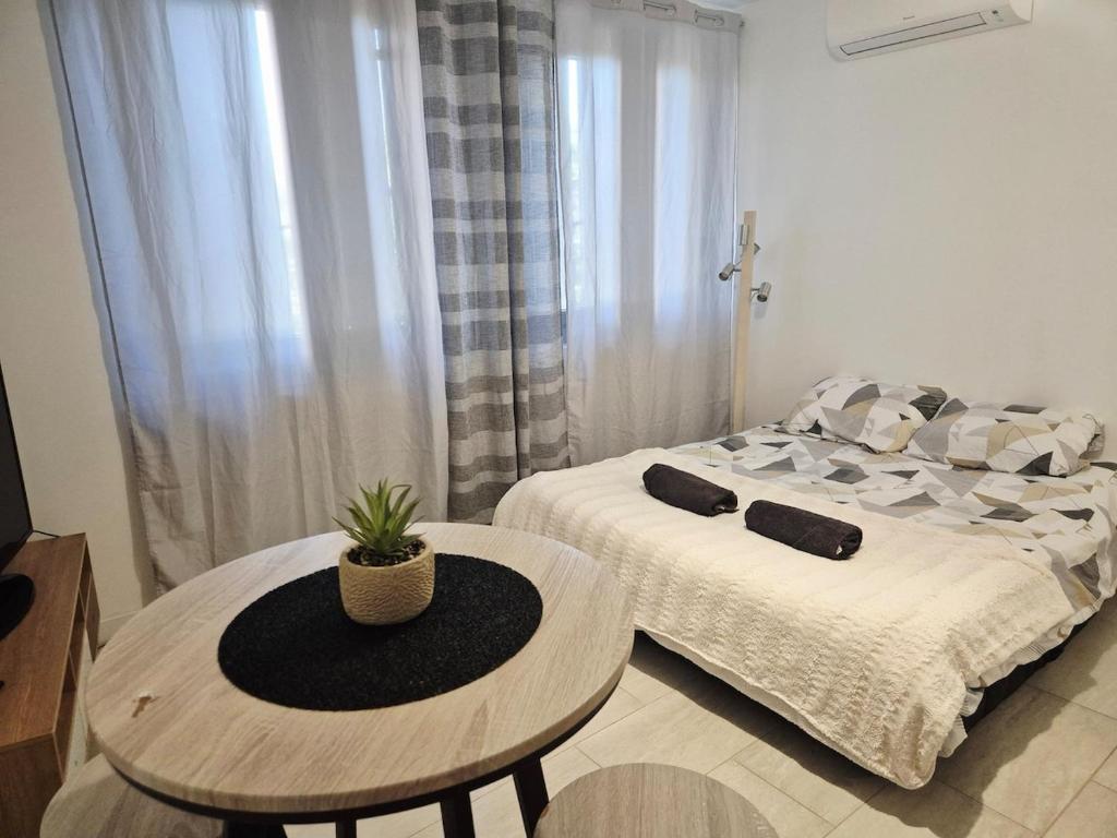 a room with a bed and a table with a table sidx sidx sidx at Studio centre-clim-parking privée-rdc in Saint-Gaudens