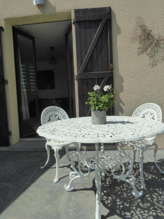 una mesa blanca y sillas con una maceta. en Apartment The Address, en Carcassonne