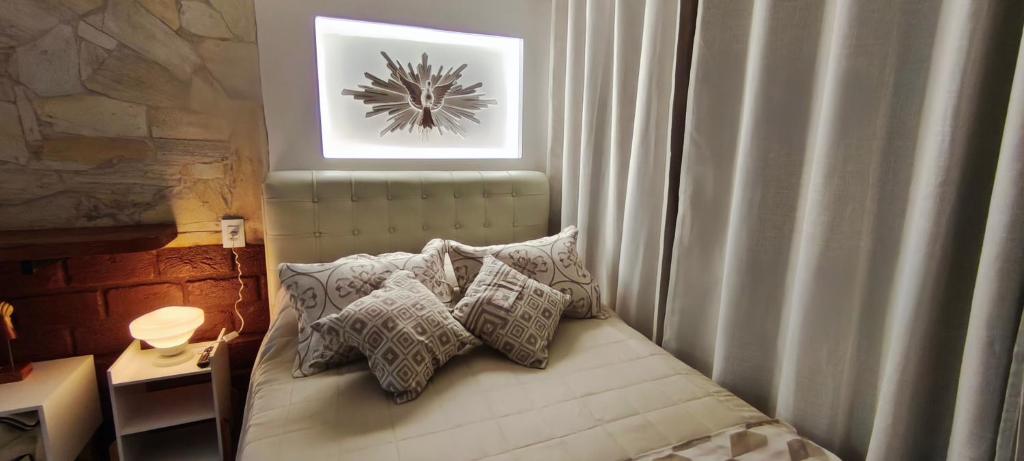 a bedroom with a bed with pillows on it at Espaço Vintage Hospedaria Suíte Alento in Prados