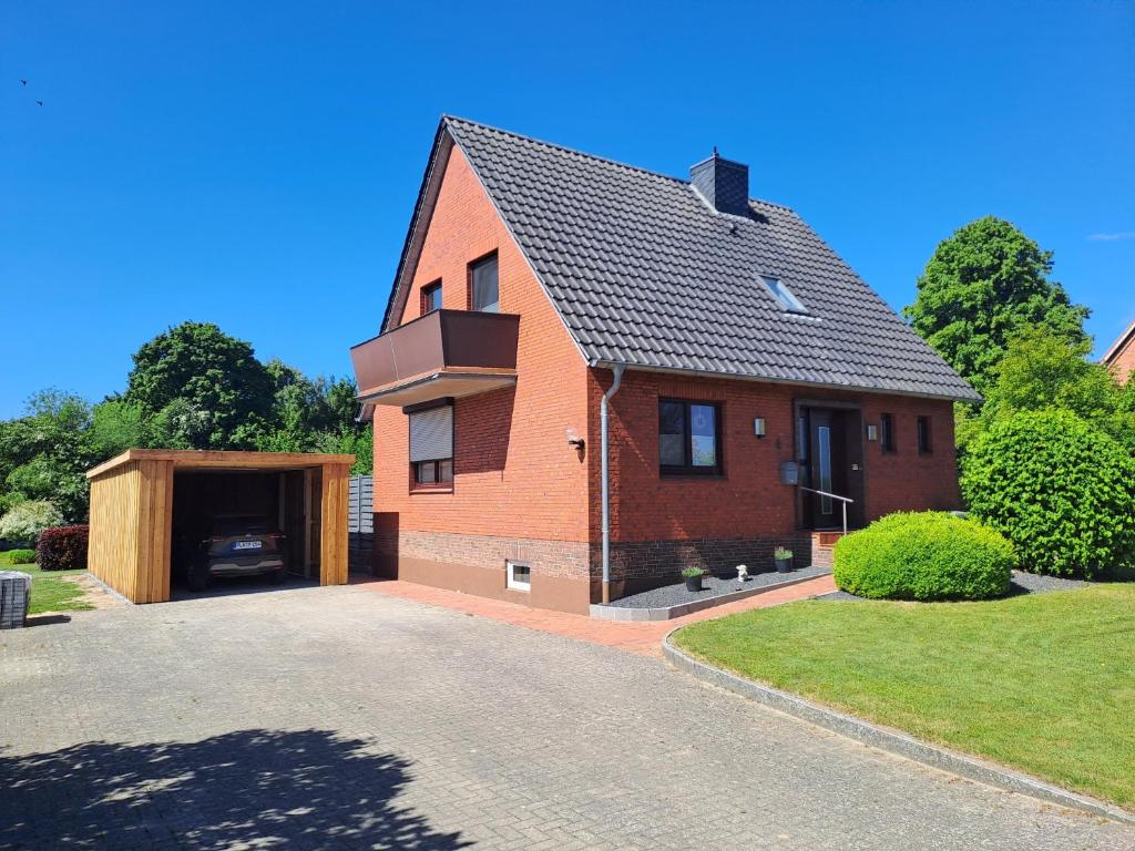 a brick house with a garage and a driveway at FeWo Petersen, Köhn in KÃ¶hn
