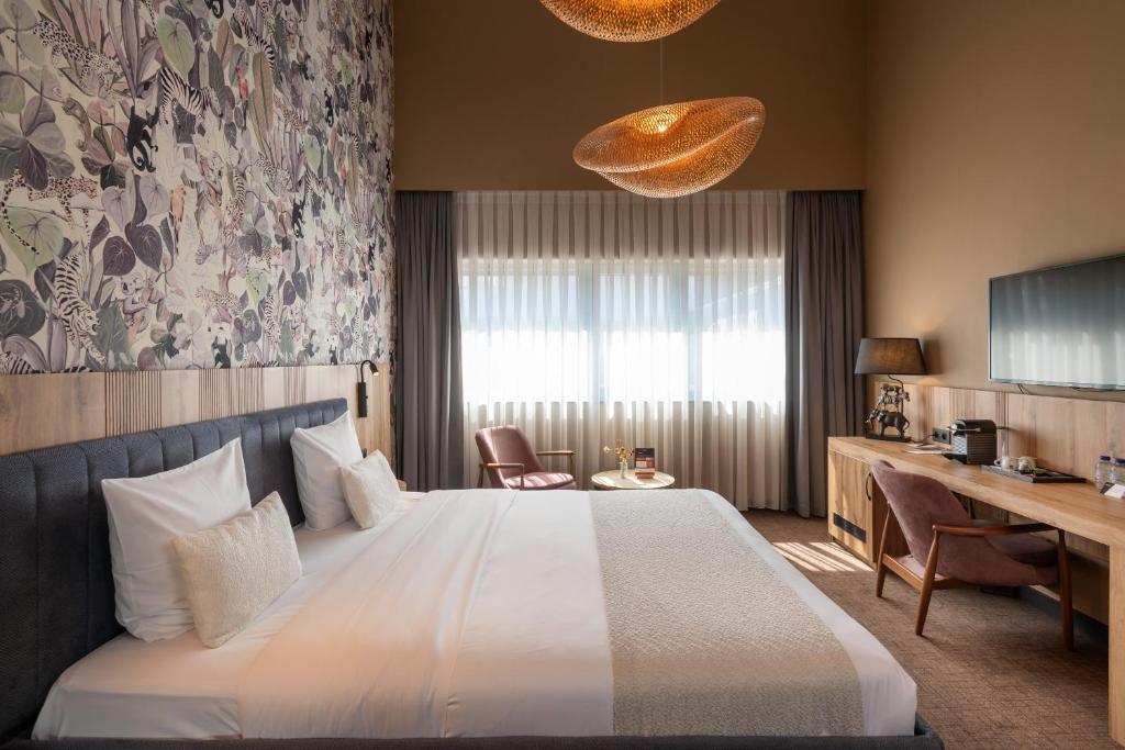 a hotel room with a bed and a desk at Hotel Le 830 Namur in Namur