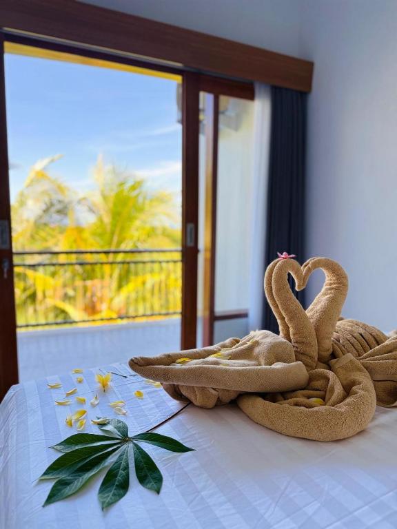 two towel swans sitting on top of a bed at MEDEWI BREEZE House in Airsatang