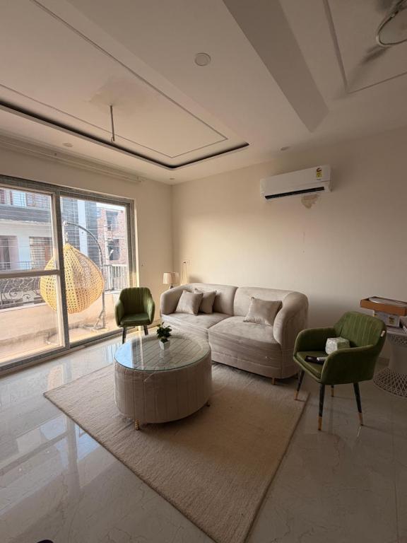 a living room with a couch and a table and chairs at Urban Nest By Jassi in Kharar