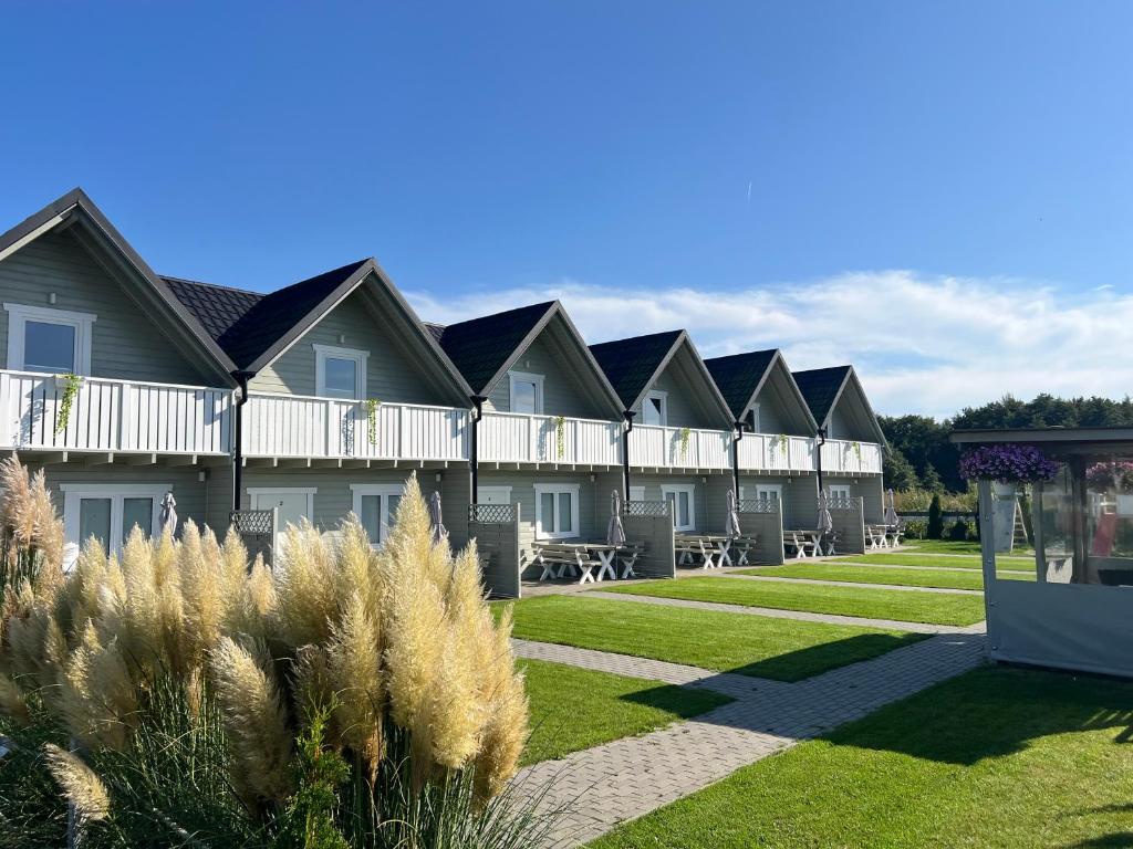 a row of houses with grass and plants at Westbeach House in Grzybowo