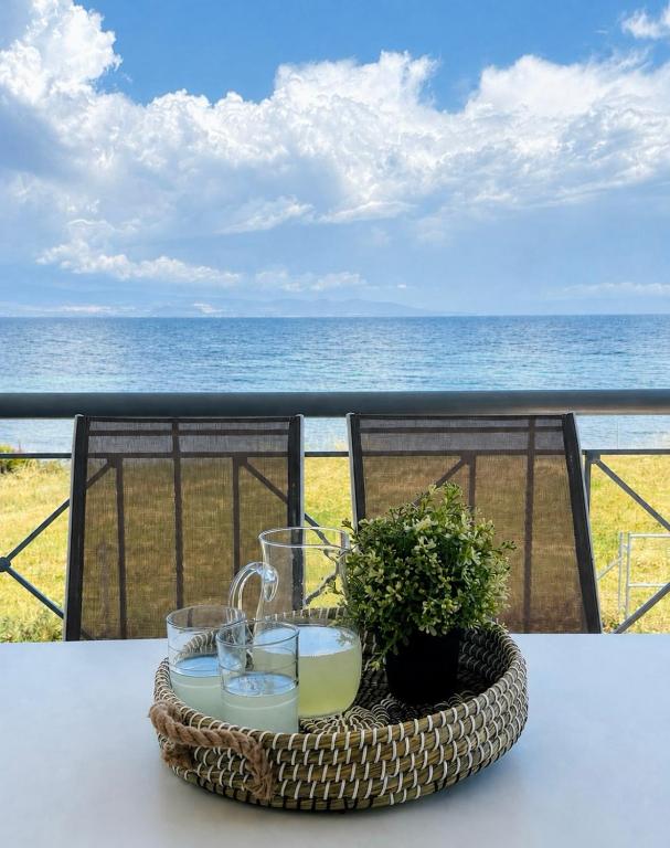 a wicker basket with a candle on a table overlooking the ocean at Starry Coast Apartments in Nea Potidaea