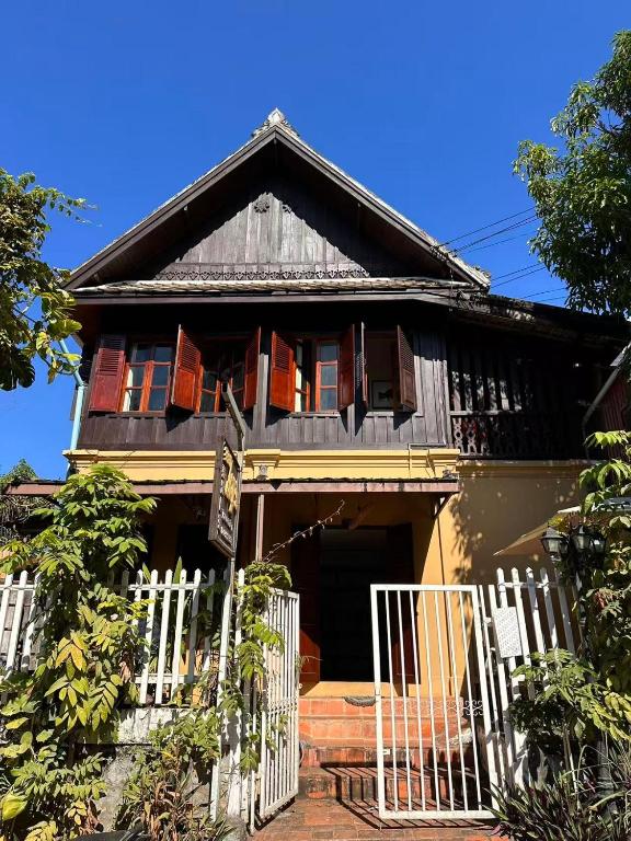 a house with a white fence in front of it at 喜悦民宿 Joy in Luang Prabang
